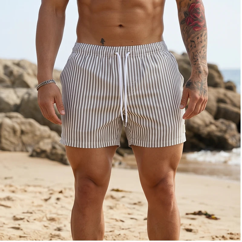 Model wearing Gray Huxley Striped Swim Trunks outdoors