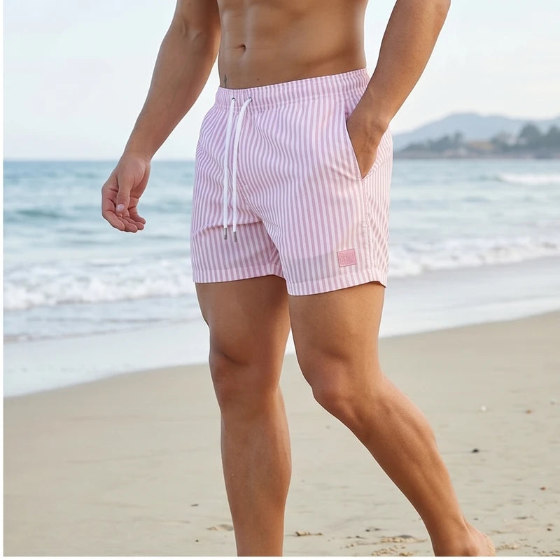Model wearing Pink Huxley Striped Swim Trunks outdoors - 2