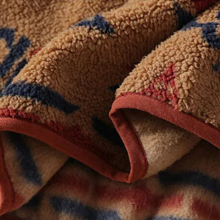 Close-up of a textured blanket with geometric patterns in brown, blue, and red.