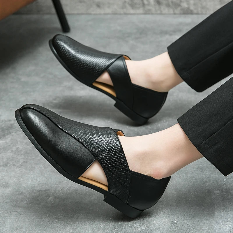 Black loafers worn by a person on a gray floor