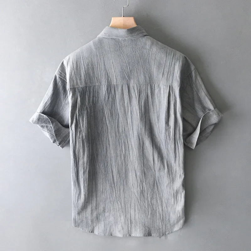 Gray short-sleeve shirt on a hanger against a gray background