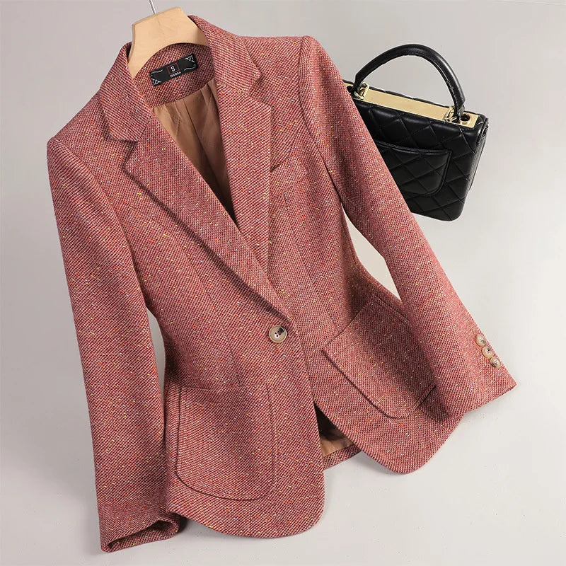 Pink blazer on a mannequin with a black handbag in the background