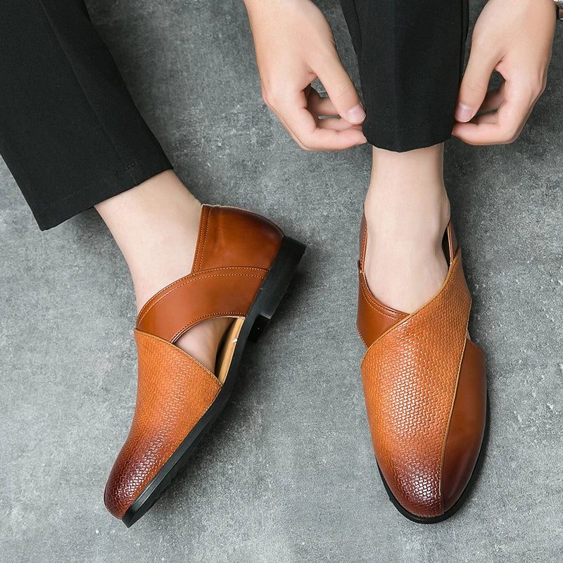 Brown leather shoes worn by a person on a gray surface