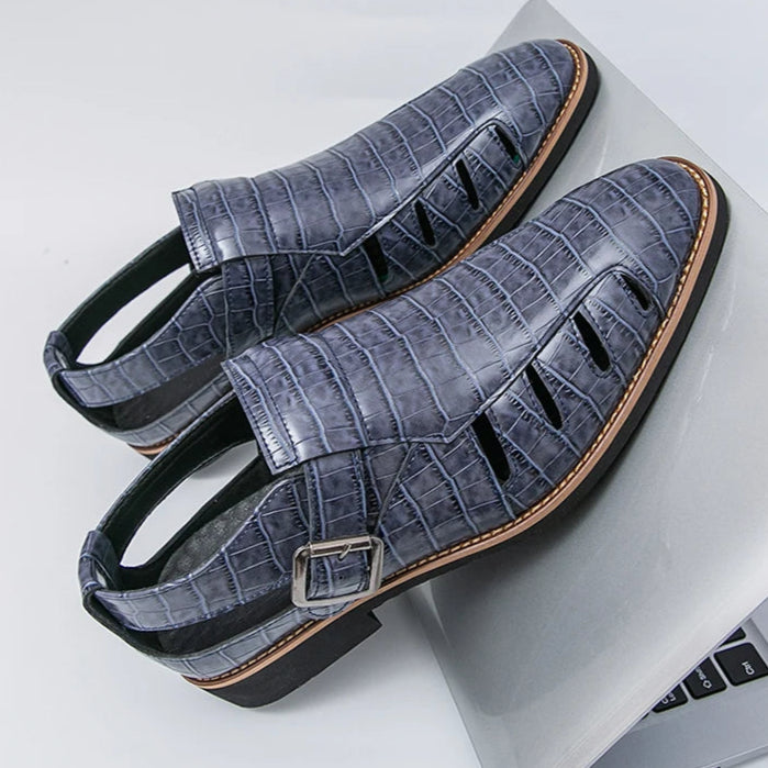 Gray sandals with a crocodile pattern on a white surface