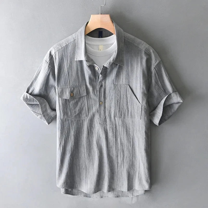 Gray short-sleeve shirt on a hanger against a gray background