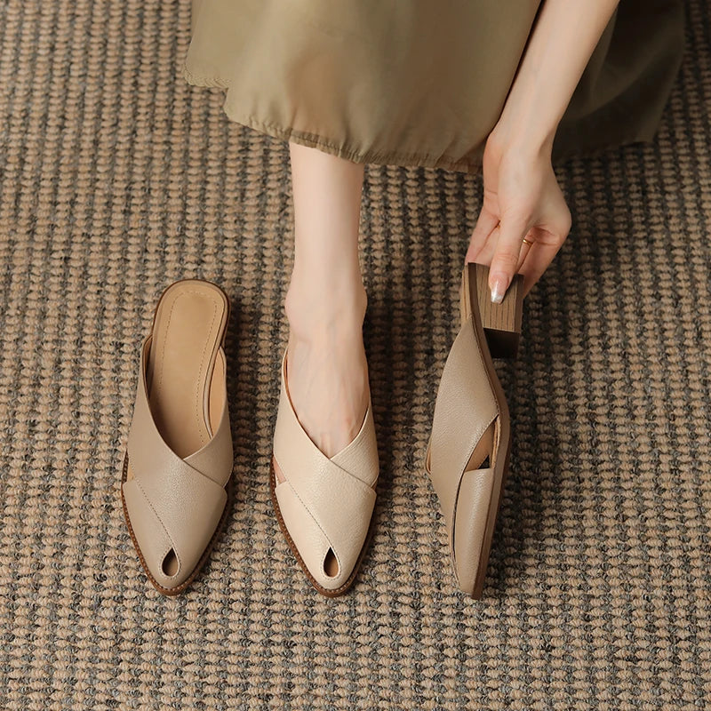Beige open-toe shoes on a textured brown surface