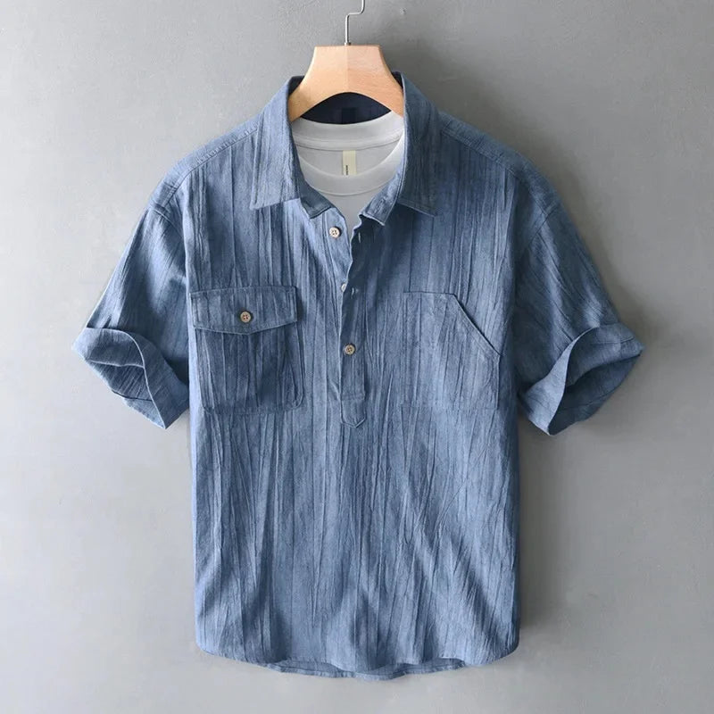 Blue striped shirt on a hanger against a gray background
