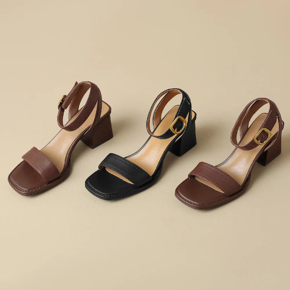 Pair of brown and black sandals on a beige background