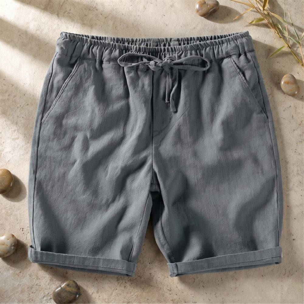 Gray linen drawstring shorts with cuffed hems.