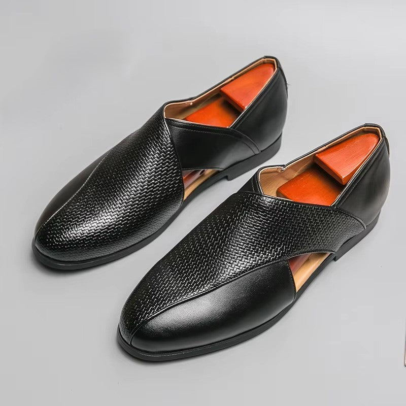 Pair of black leather shoes with orange lining on a gray background