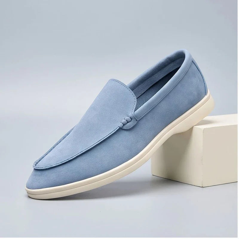 sky blue suede loafers in a studio background