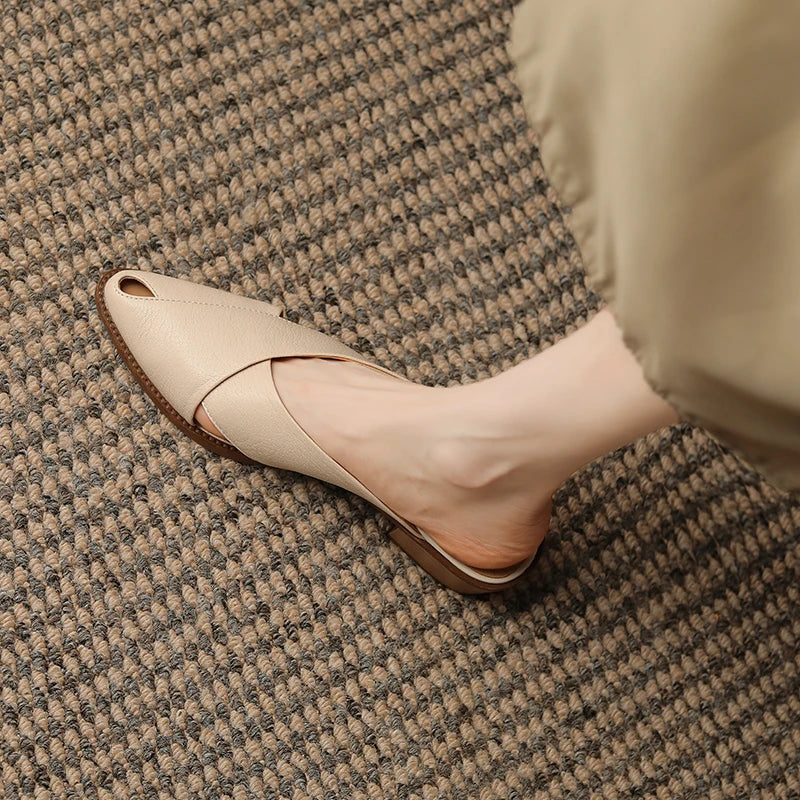 Beige flat shoe worn on a textured carpet