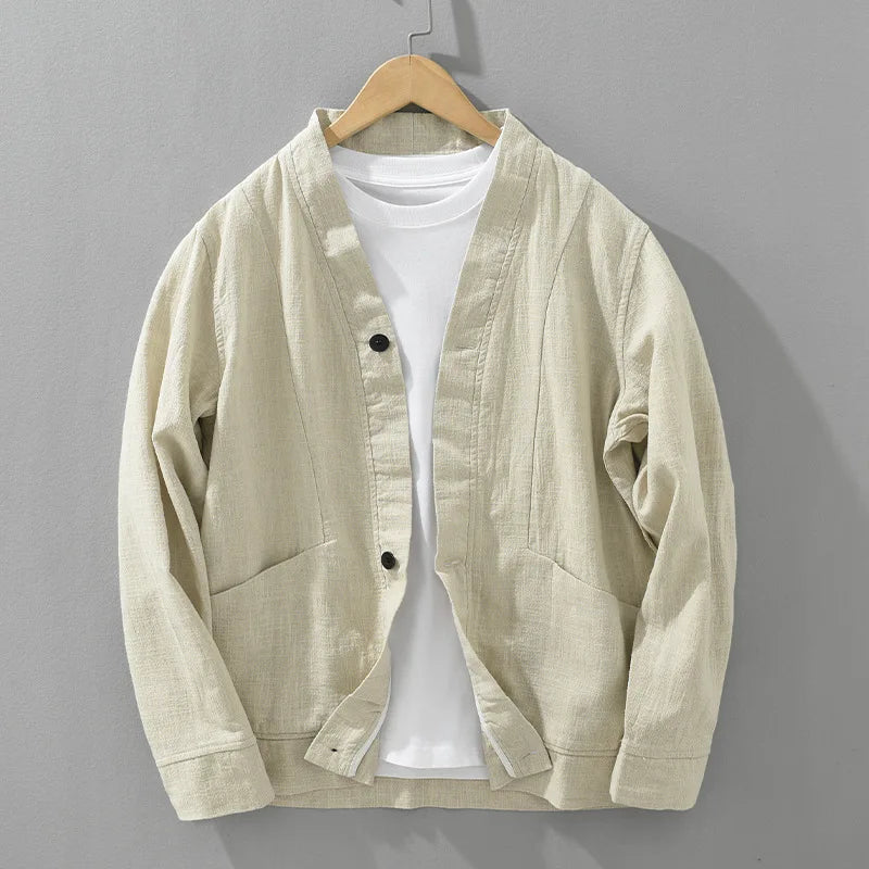 Beige linen jacket on a hanger against a gray background