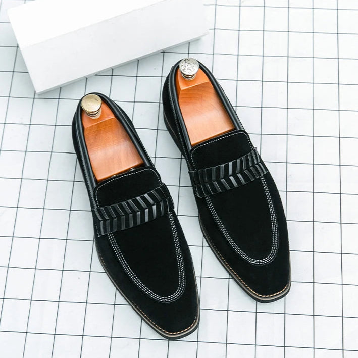 Pair of black loafers on a grid background