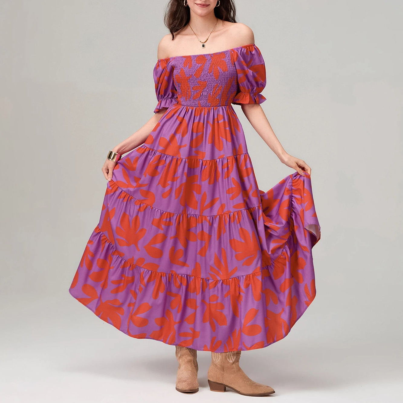 Woman wearing a purple and orange floral dress on a plain background