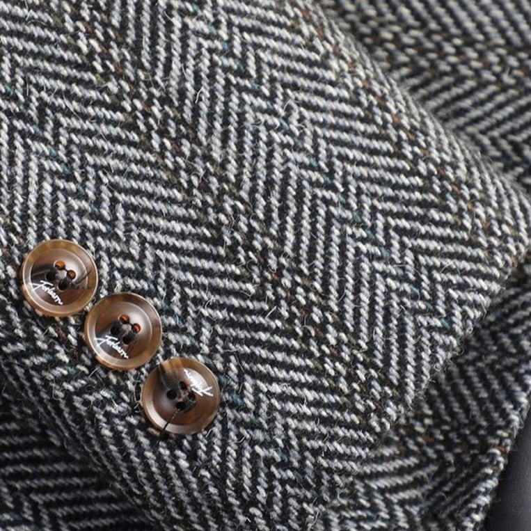 Close-up of a gray herringbone patterned fabric with buttons.