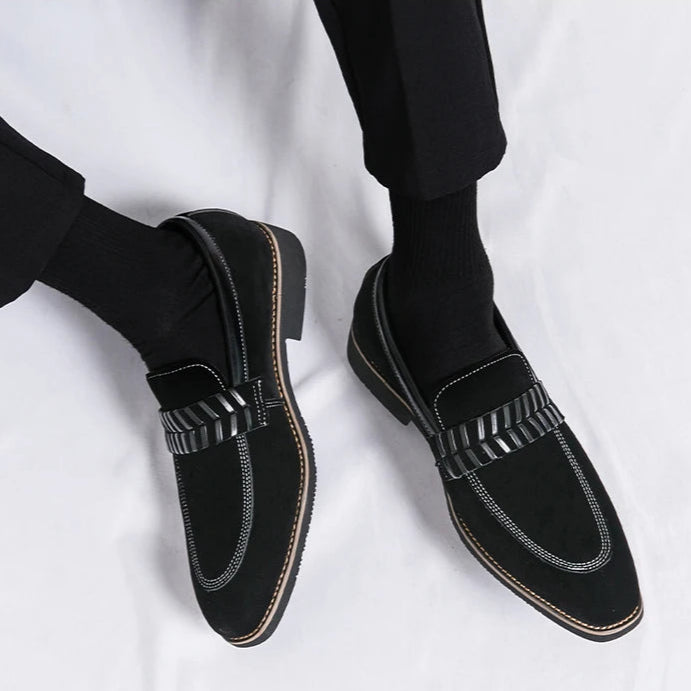 Black loafers worn with black pants on a white background