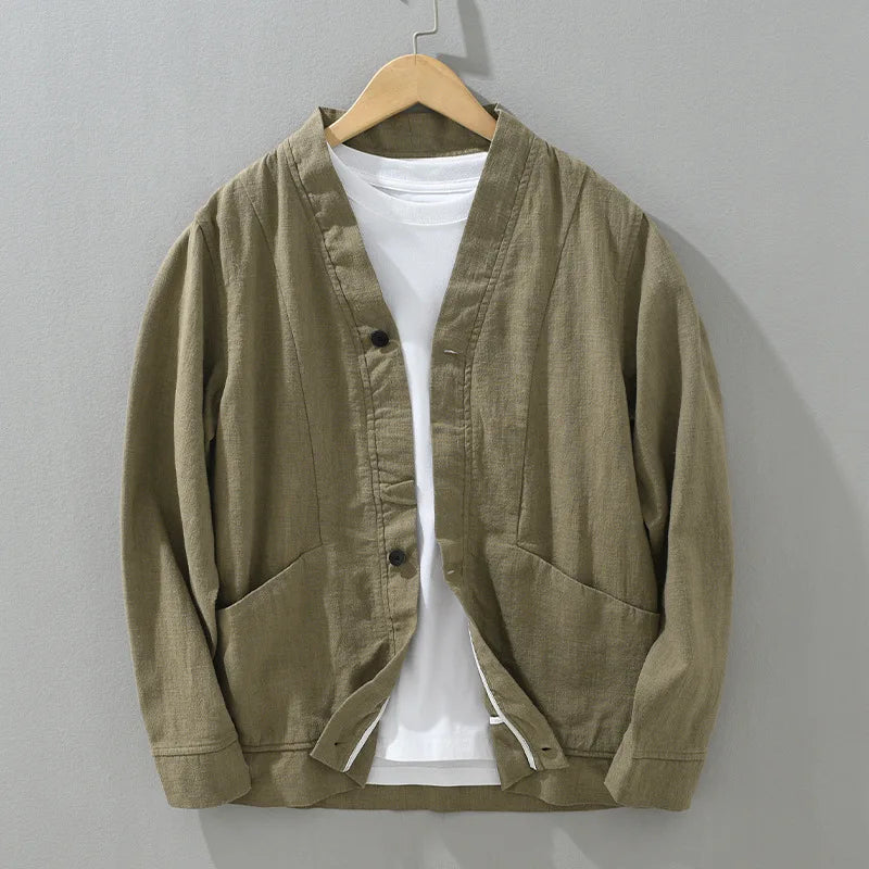 Brown linen jacket on a hanger against a gray background