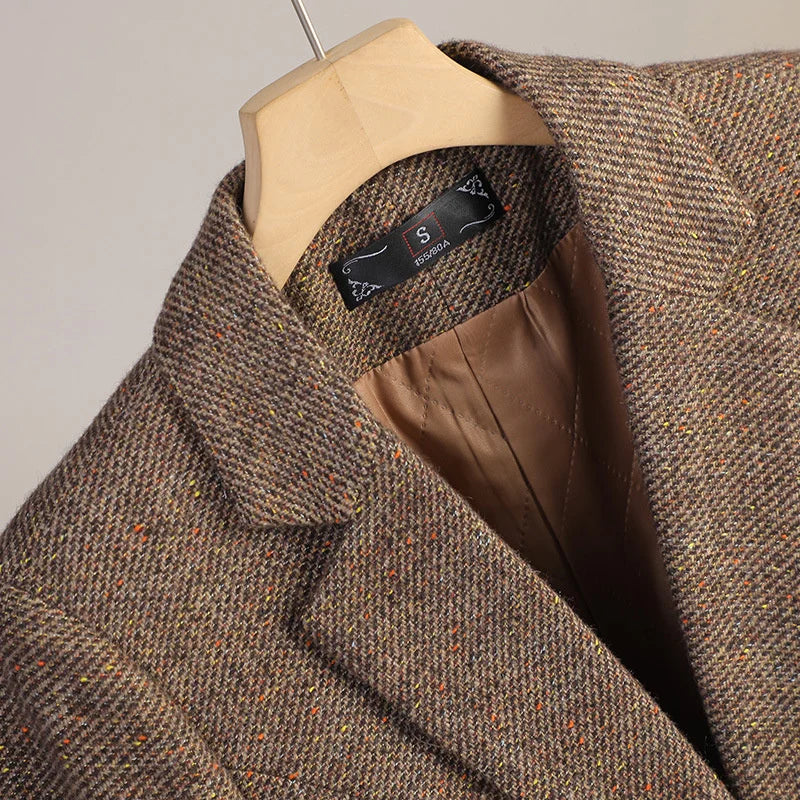 Brown tweed jacket on a mannequin with a visible brand label against a neutral background