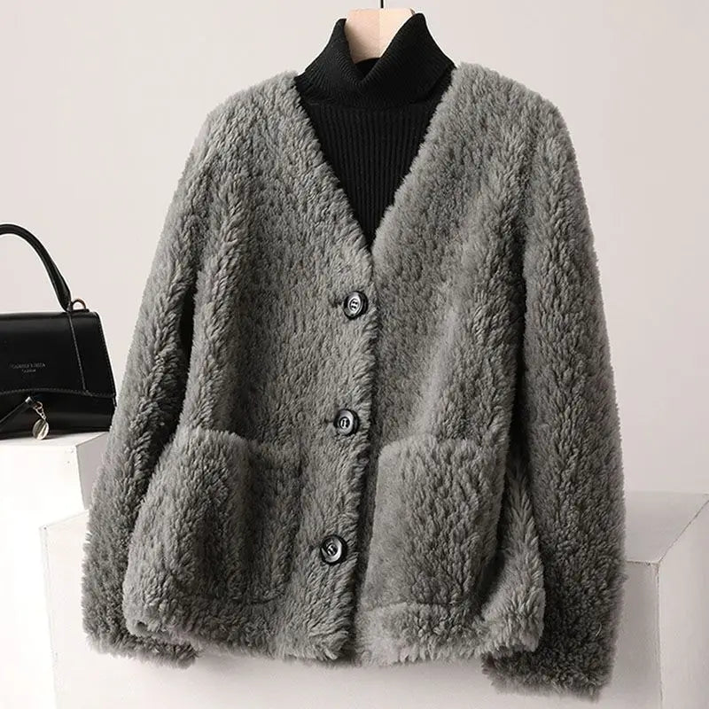 Gray fluffy cardigan on a mannequin with a black handbag in the background