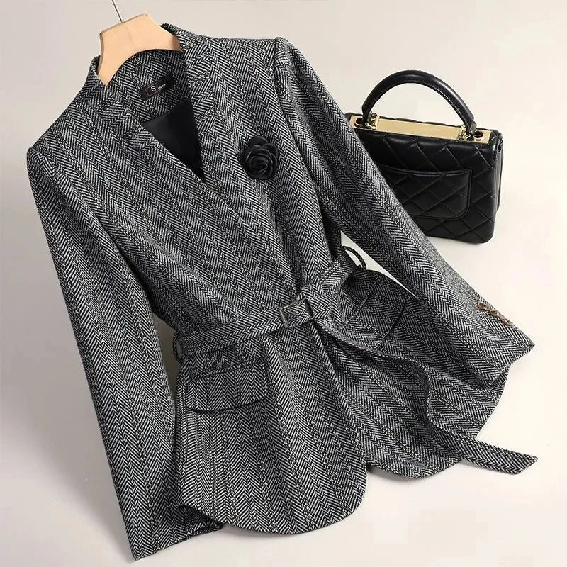 Gray herringbone coat with a black handbag on a light background