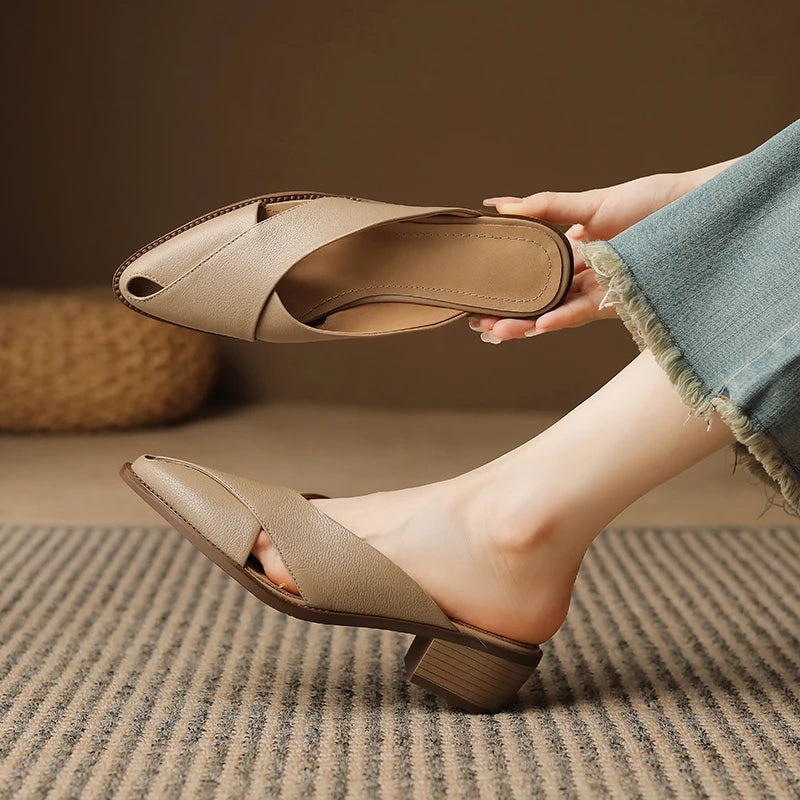 Beige high-heeled shoes being worn with a blurred background