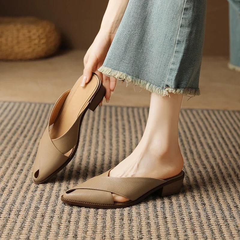 Person wearing beige open-toe shoes on a striped rug