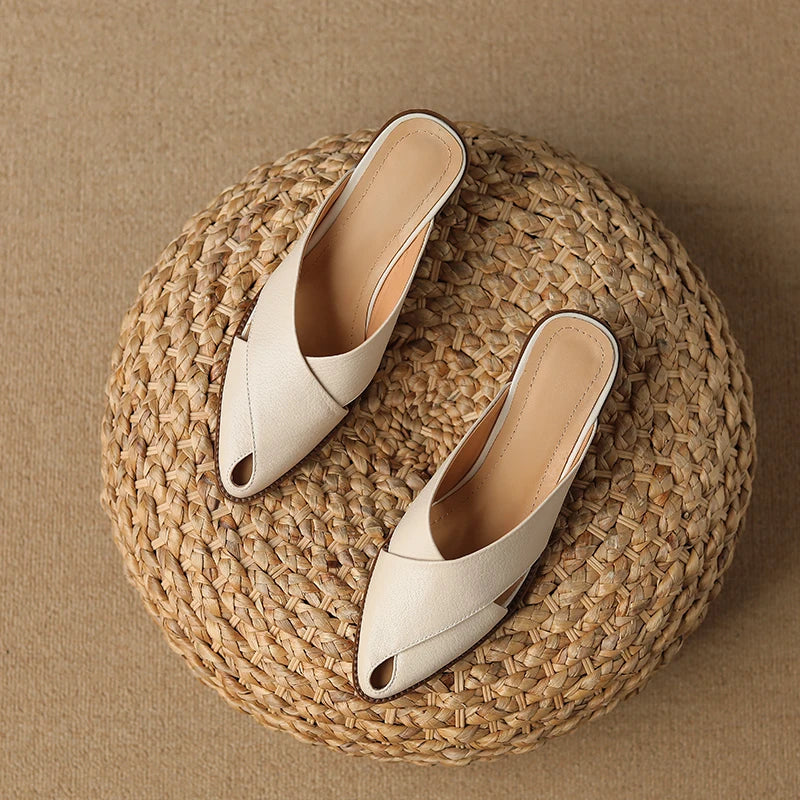 Pair of white open-toe shoes on a woven mat with a brown background