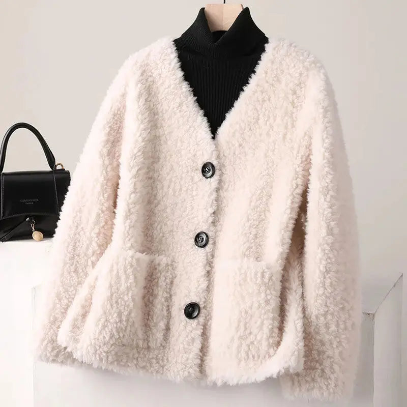 White fluffy cardigan on a mannequin with a black handbag in the background
