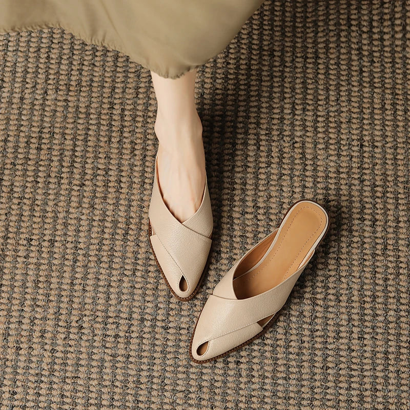 Beige open-toe shoes on a textured brown carpet