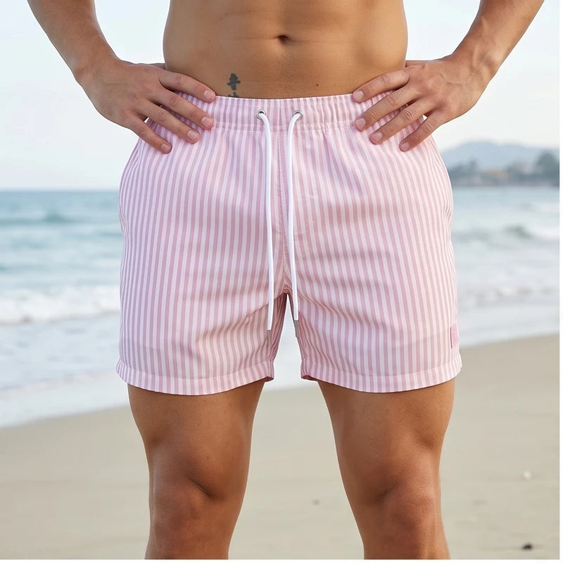 Model wearing Pink Huxley Striped Swim Trunks outdoors
