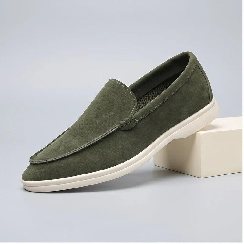 green suede loafers in a studio background