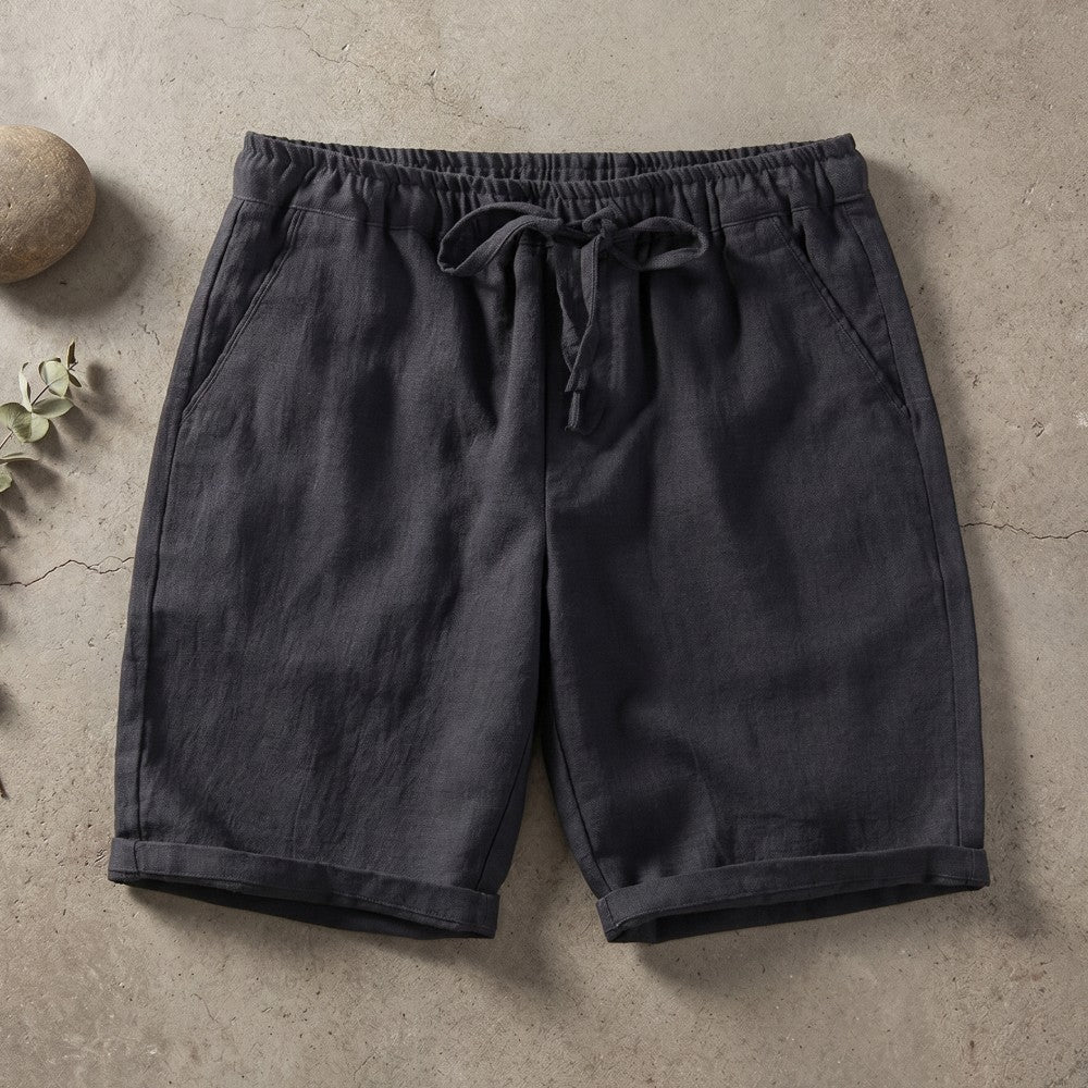 Dark gray linen drawstring shorts with cuffed hems.