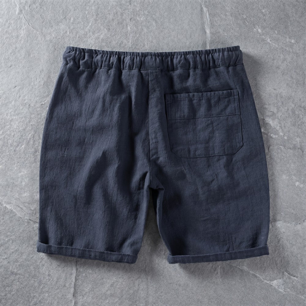 Navy linen drawstring shorts with a single back pocket.