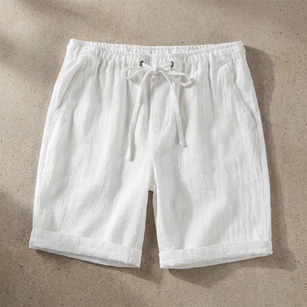 White linen drawstring shorts with rolled hem.